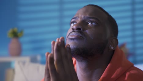 Young-black-man-at-home-alone-hoping,-praying,-looking-at-the-sky.